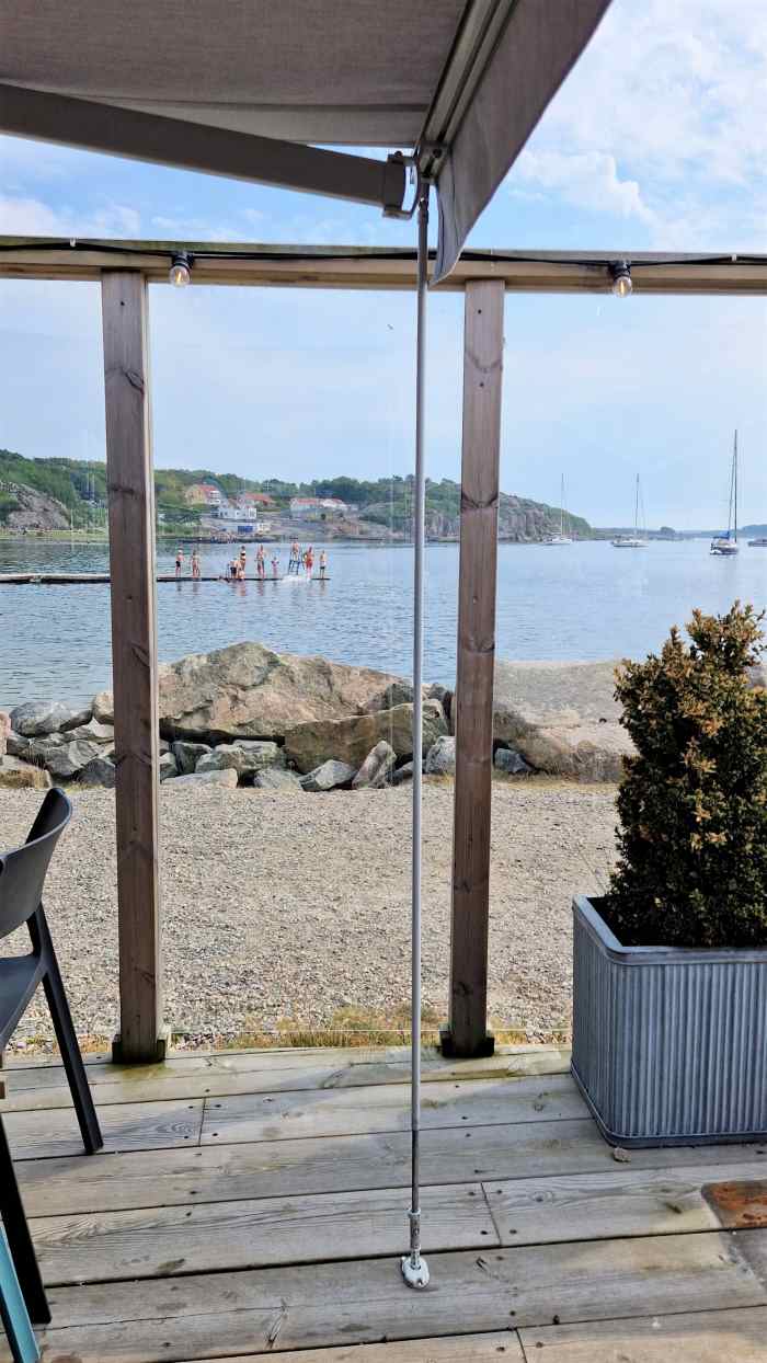 Långt vindstag som är nerfällt och fastsatt i golvfästet för att förhindra att terrassmarkisen hoppa i vinden och gör terrassmarkisen betydligt mer vindtålig. Terrassmarkis från Markisrea.se med Vindstag. Sandatex markisväv.