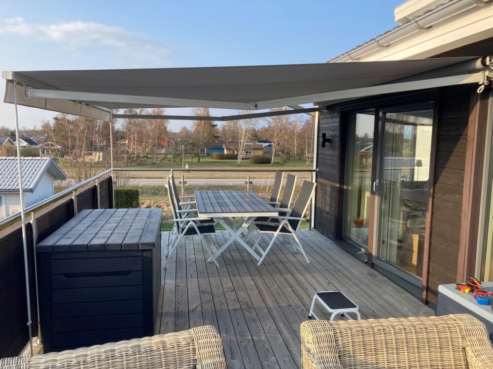 Stor terrassmarkis med radiomotor och långa vindstag med Sandatex ljusgrå markisväv nr 79 och rak kappa