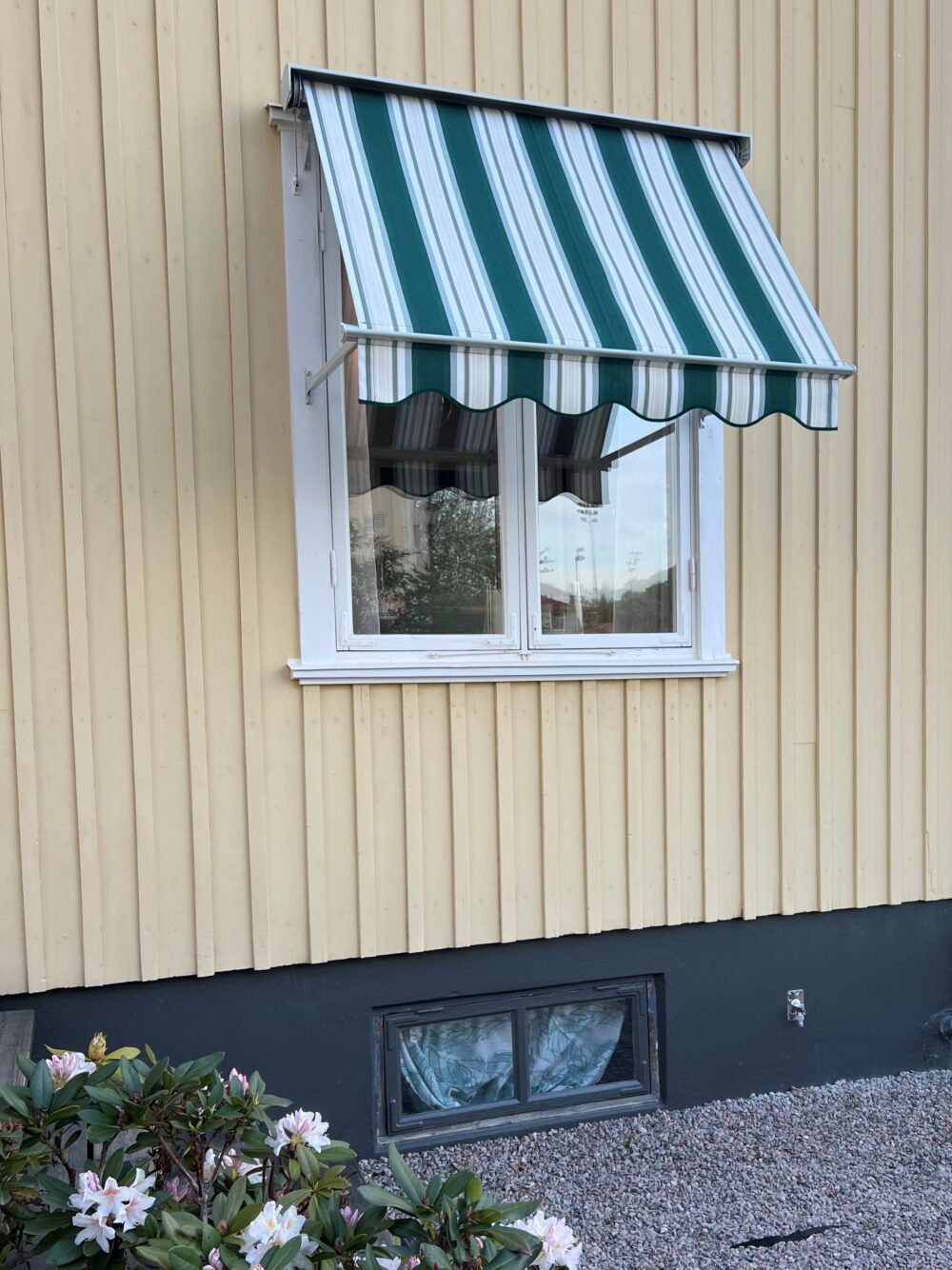 Fönstermarkis bredd 140cm x 80arm monterad med nischkonsoler 60mm. Ljusgrå lack på kassett, profiler samt armar mm. Sandatex markisväv nr. 641-05, vågig kappa.