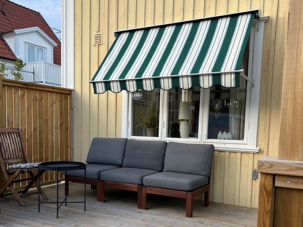 Fönstermarkis bredd 200cm x armutfall 80cm monterad med nischkonsoler 60mm. Ljusgrå lack på kassett, profiler samt armar mm. Sandatex markisväv nr. 641-05, vågig kappa.