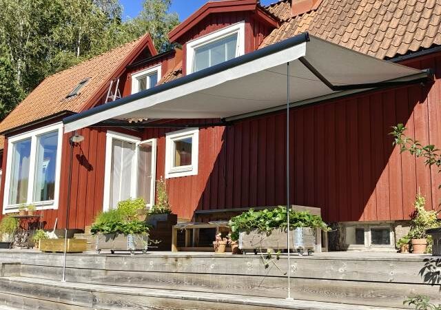 Terrassmarkis, bredd 450cm x utfall 410cm med Sunflex vinklingsfunktion. Svart aluminiumtak, Långa vindstag. Sandatex markisväv nr. 727-515 rak kappa