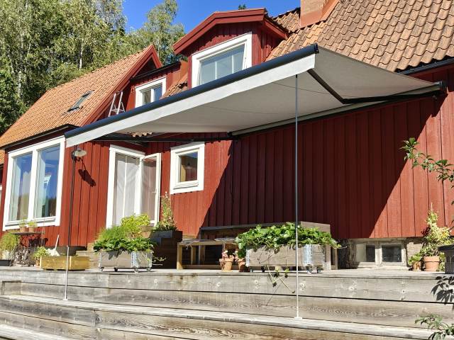 Terrassmarkis, bredd 450cm x utfall 410cm med Sunflex vinklingsfunktion. Svart aluminiumtak, Långa vindstag. Sandatex markisväv nr. 727-515 rak kappa