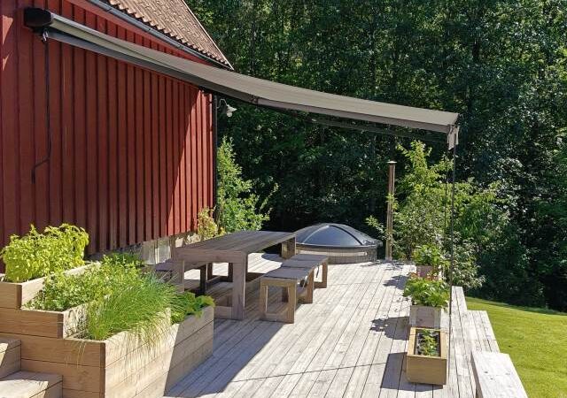 Terrassmarkis, bredd 450cm x utfall 410cm med Sunflex vinklingsfunktion. Svart aluminiumtak, Långa vindstag. Sandatex markisväv nr. 727-515 rak kappa.